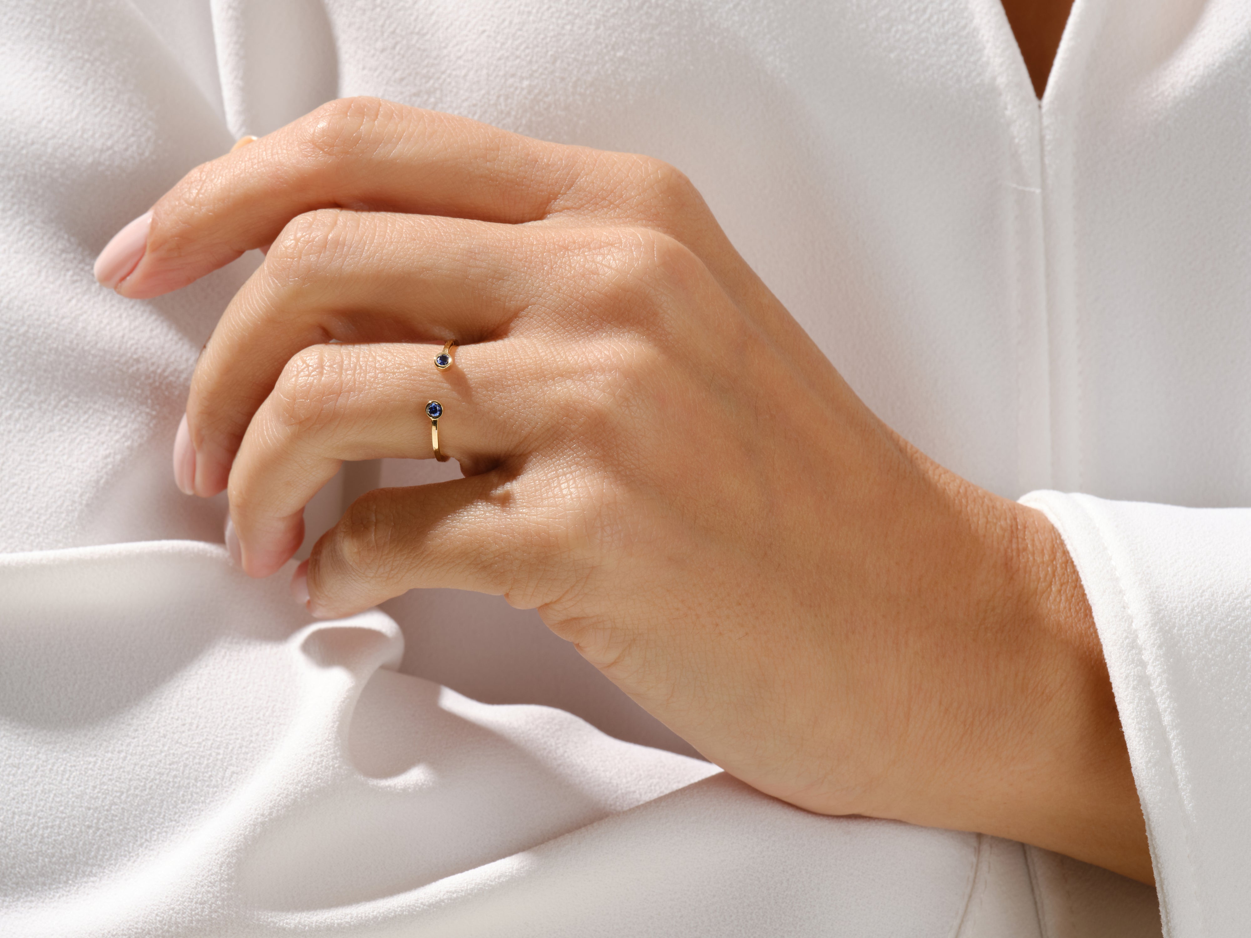 Gold ring with blue sapphires on a hand