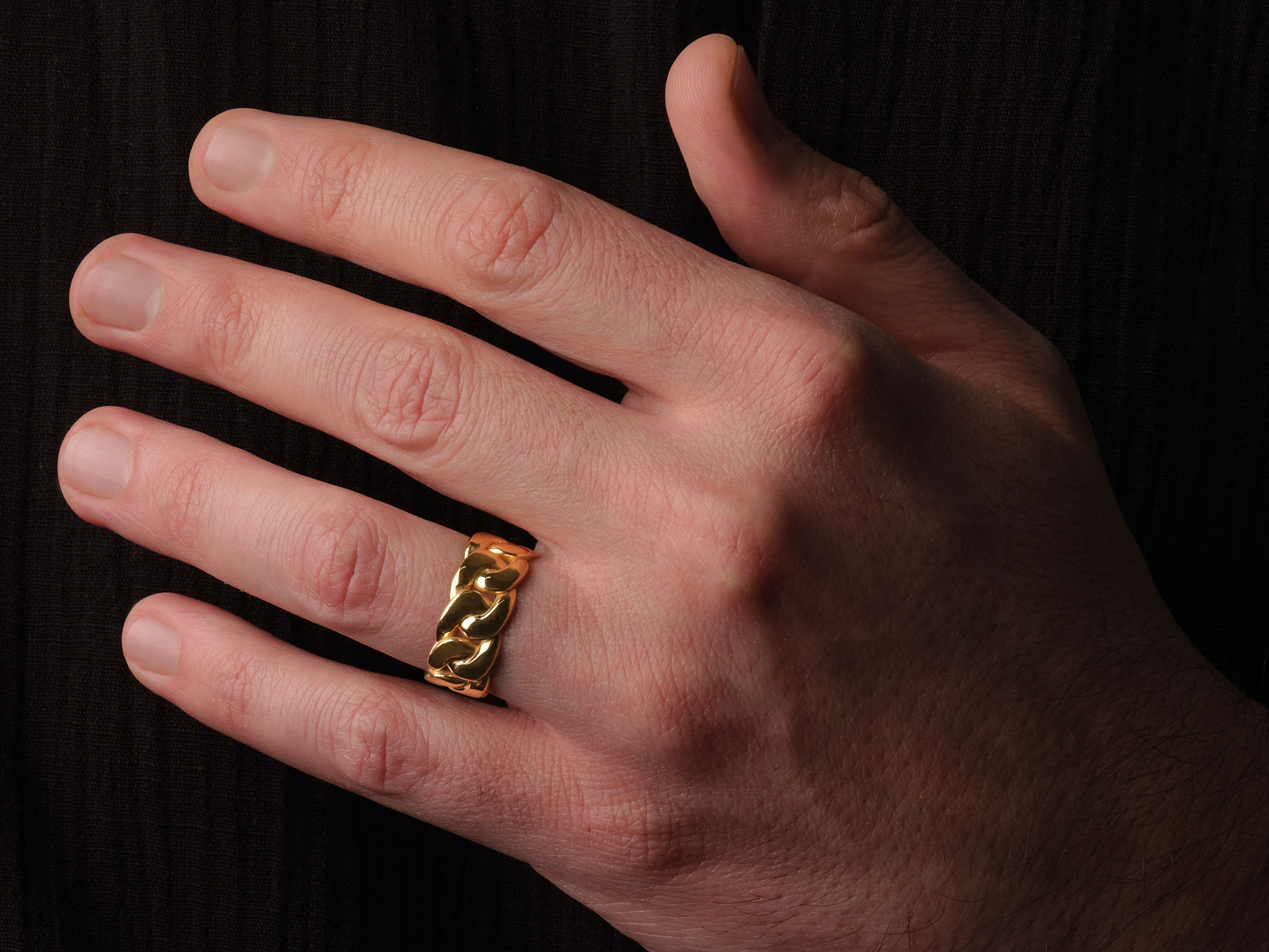 Gold curb chain ring on a man's finger