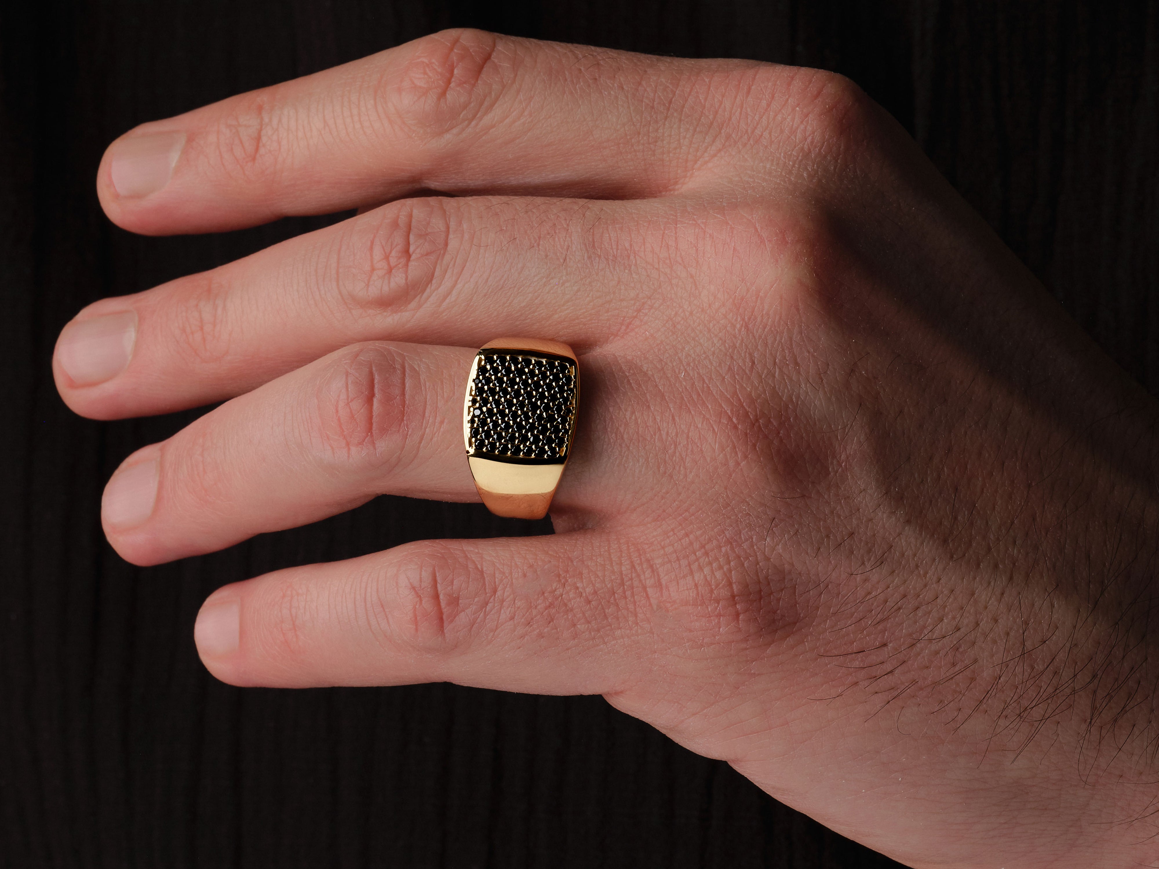 Gold ring with black diamonds on a man's finger