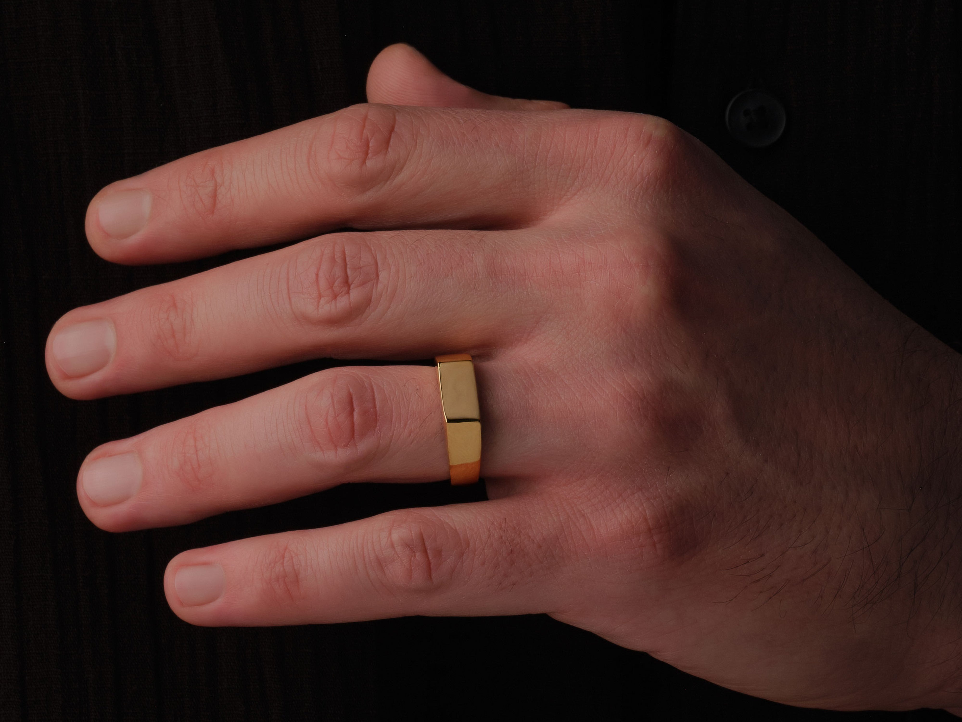 Gold band ring on a man's finger, jewelry product