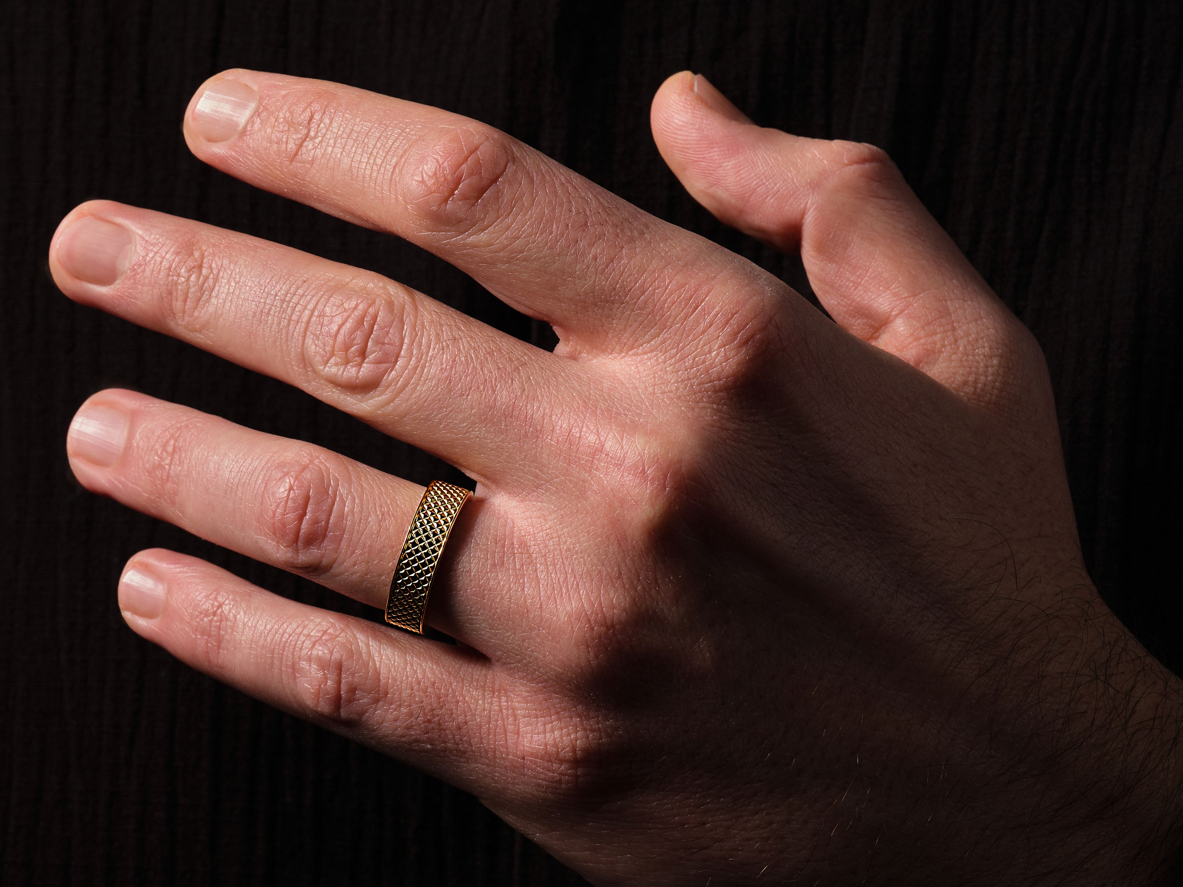 Gold textured ring on a man's hand, jewelry photography