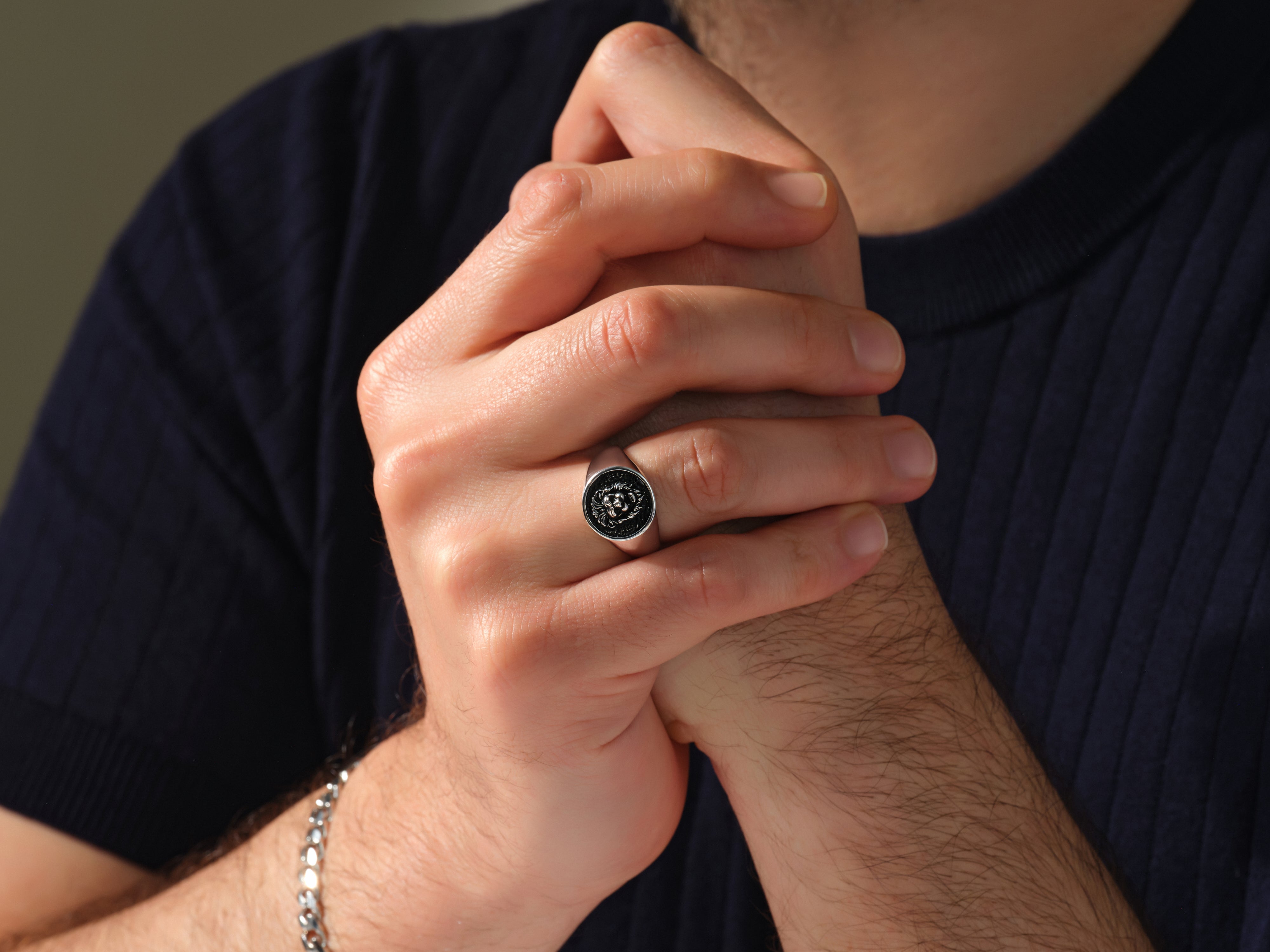 Men's silver signet ring with intricate black design, jewelry