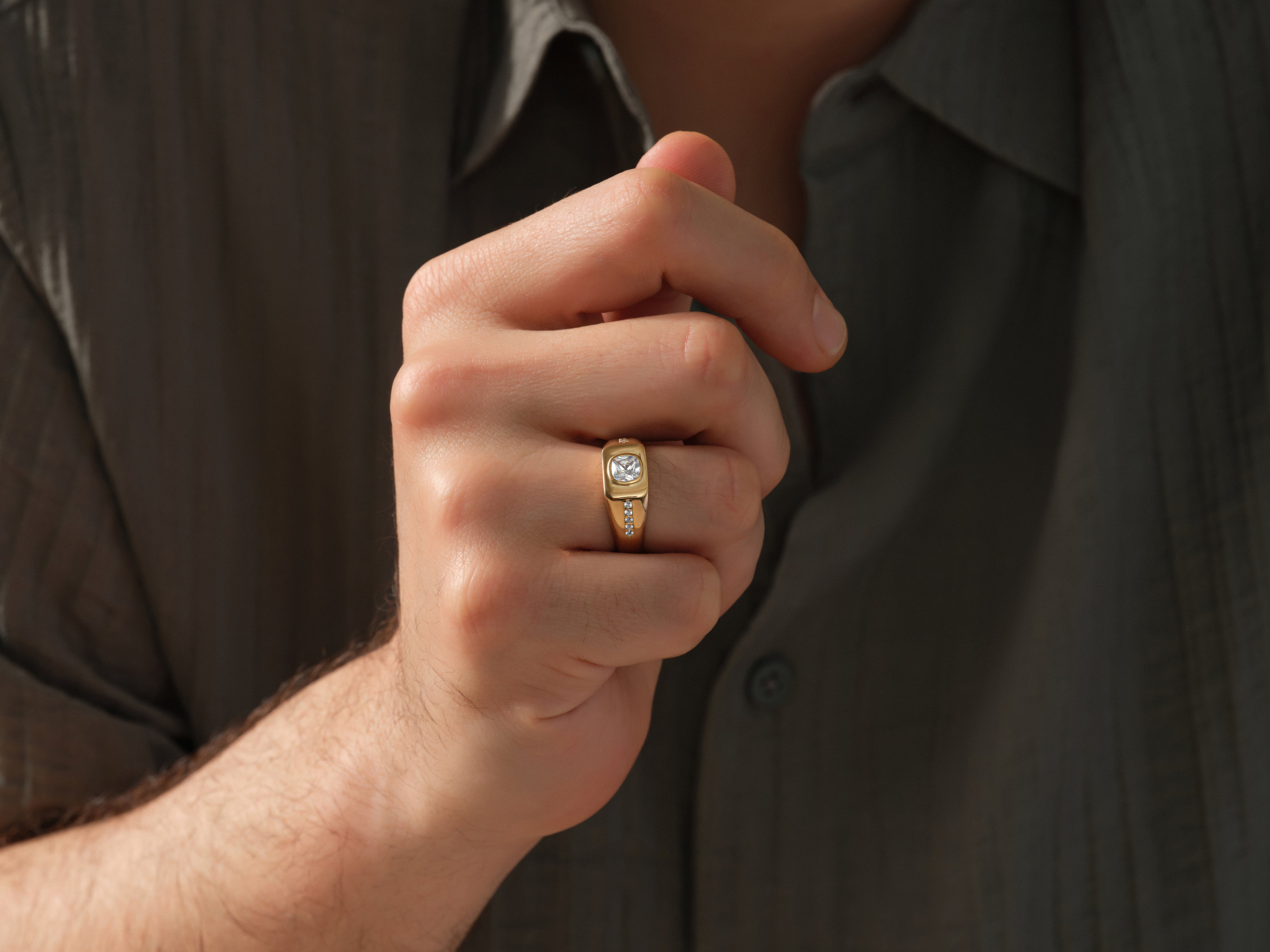 Gold ring with diamonds on man's finger, luxury jewelry