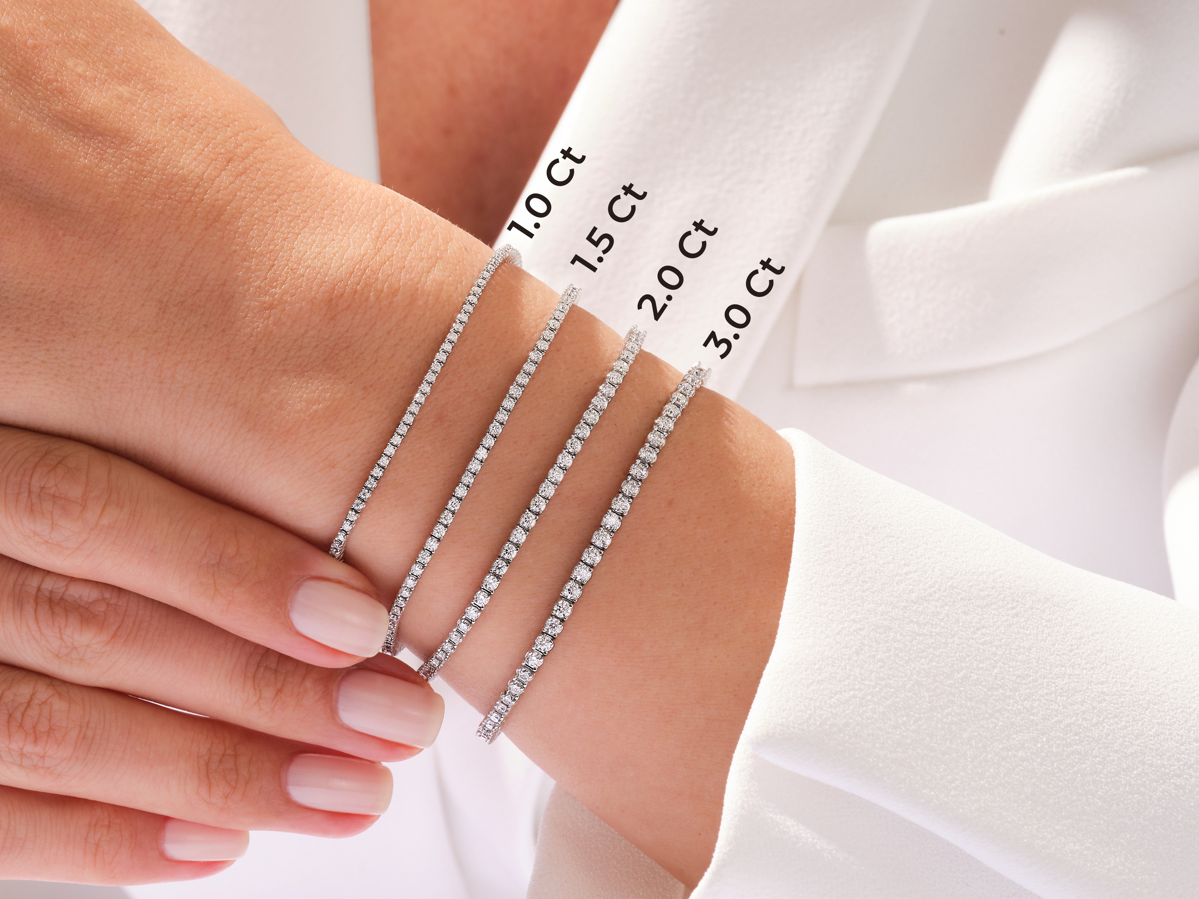 Diamond tennis bracelets in various carat weights on a woman's wrist