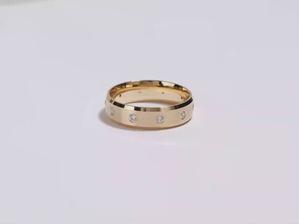 A video showing a yellow gold matte beveled ten stone eternity men's diamond wedding band spinning on a white background