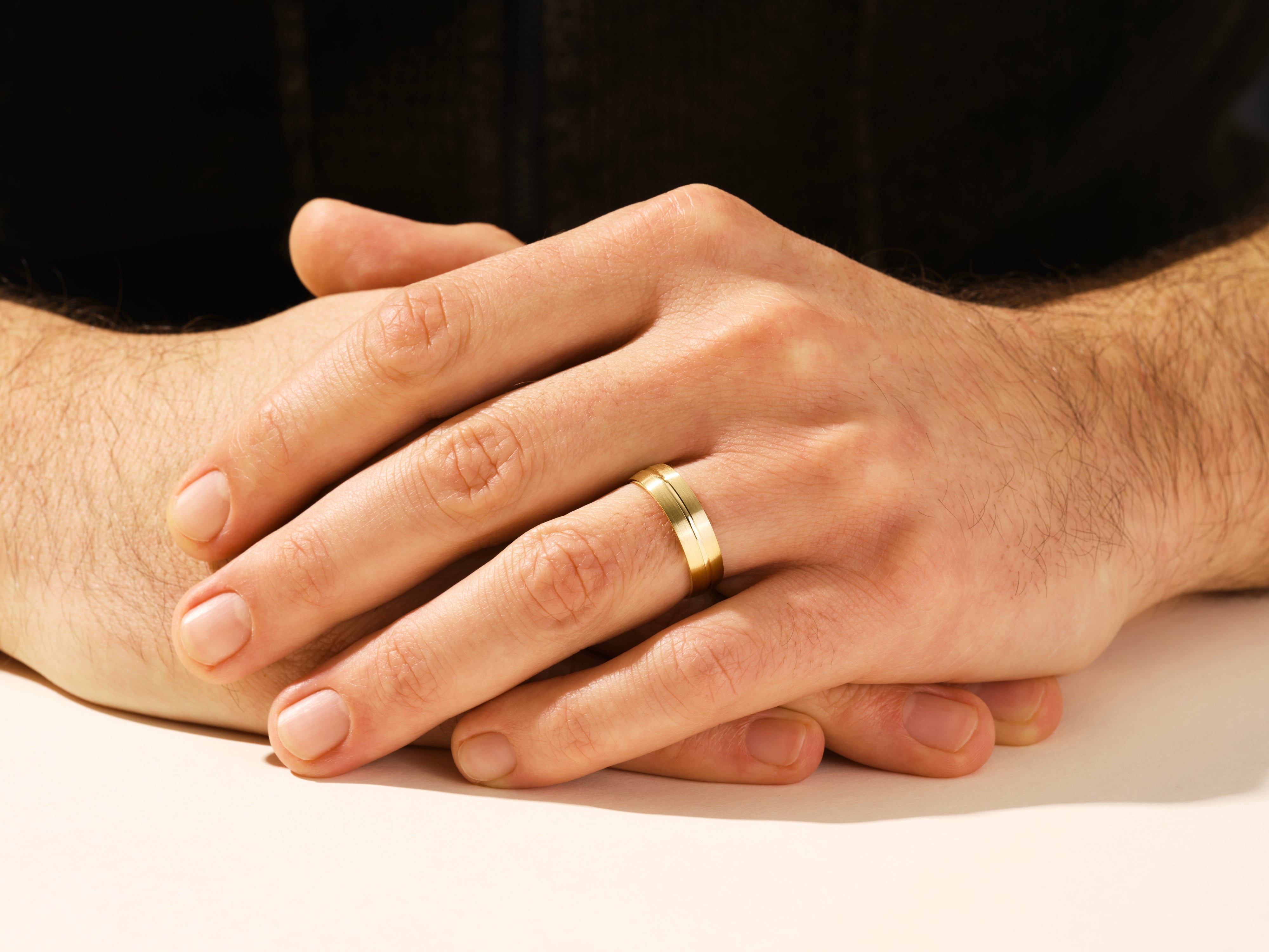 Gold wedding band on a man's finger, jewelry for him