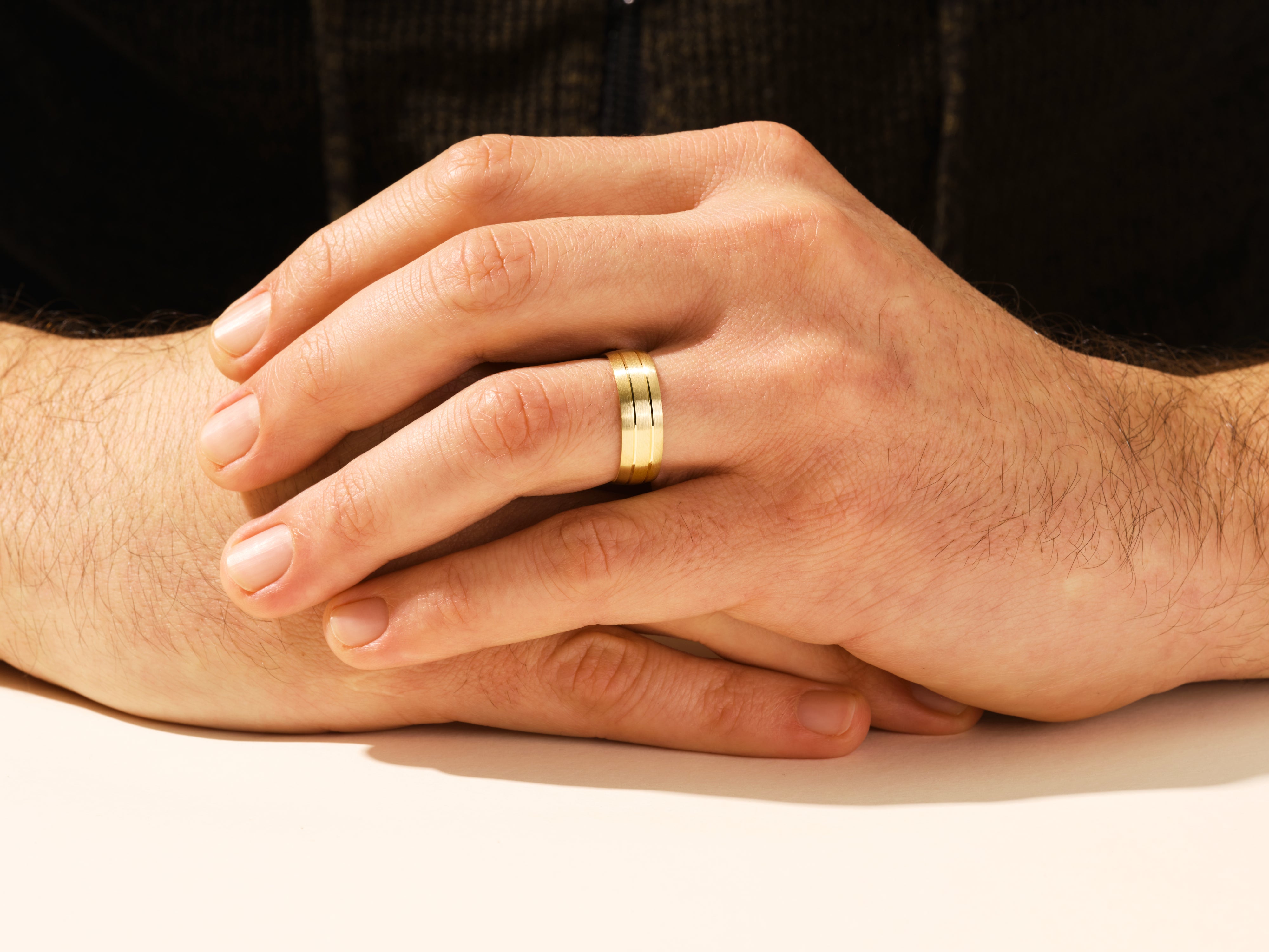 Gold wedding band on man's hand, jewelry for men
