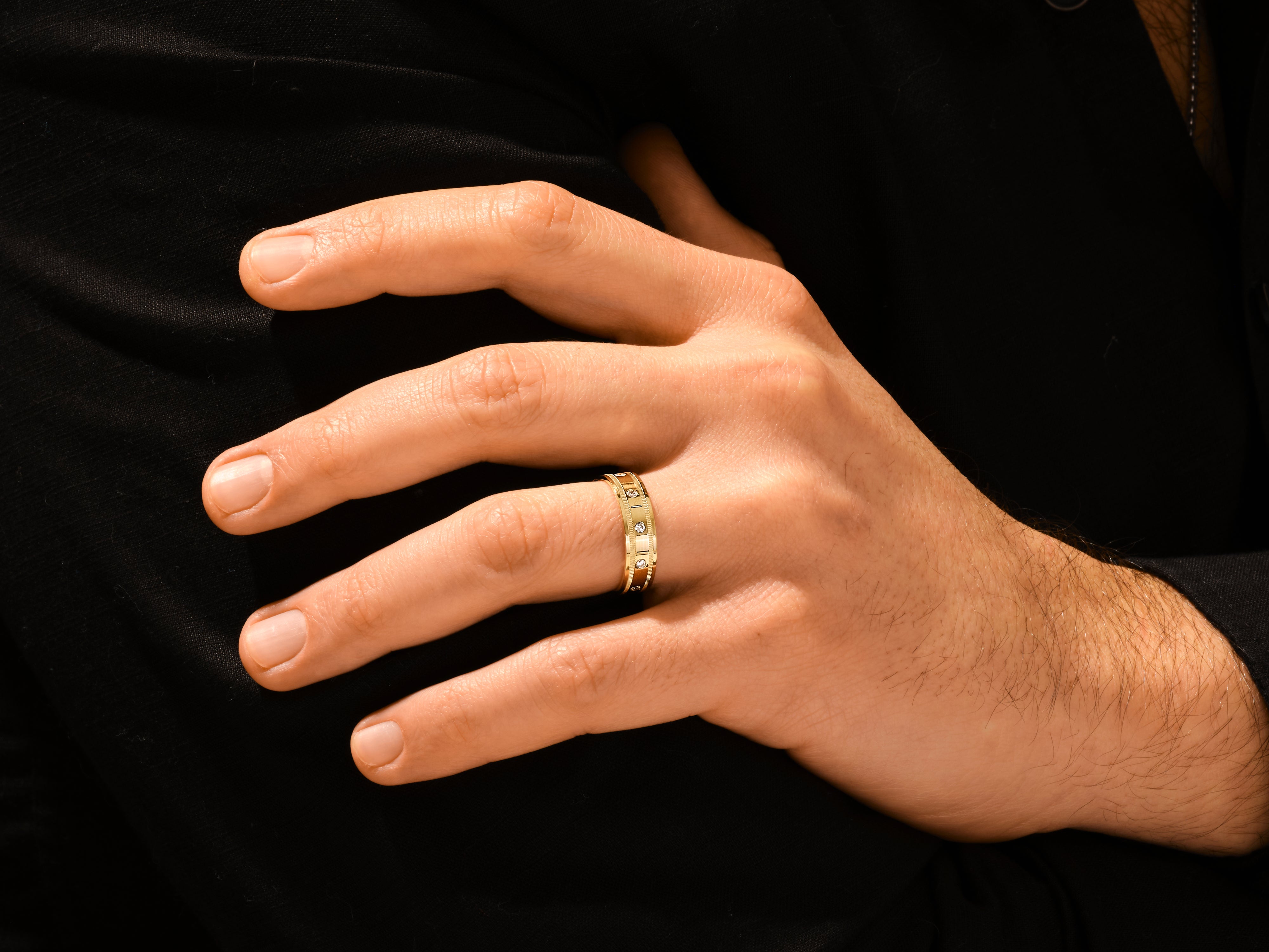 Gold ring with diamonds on a man's finger