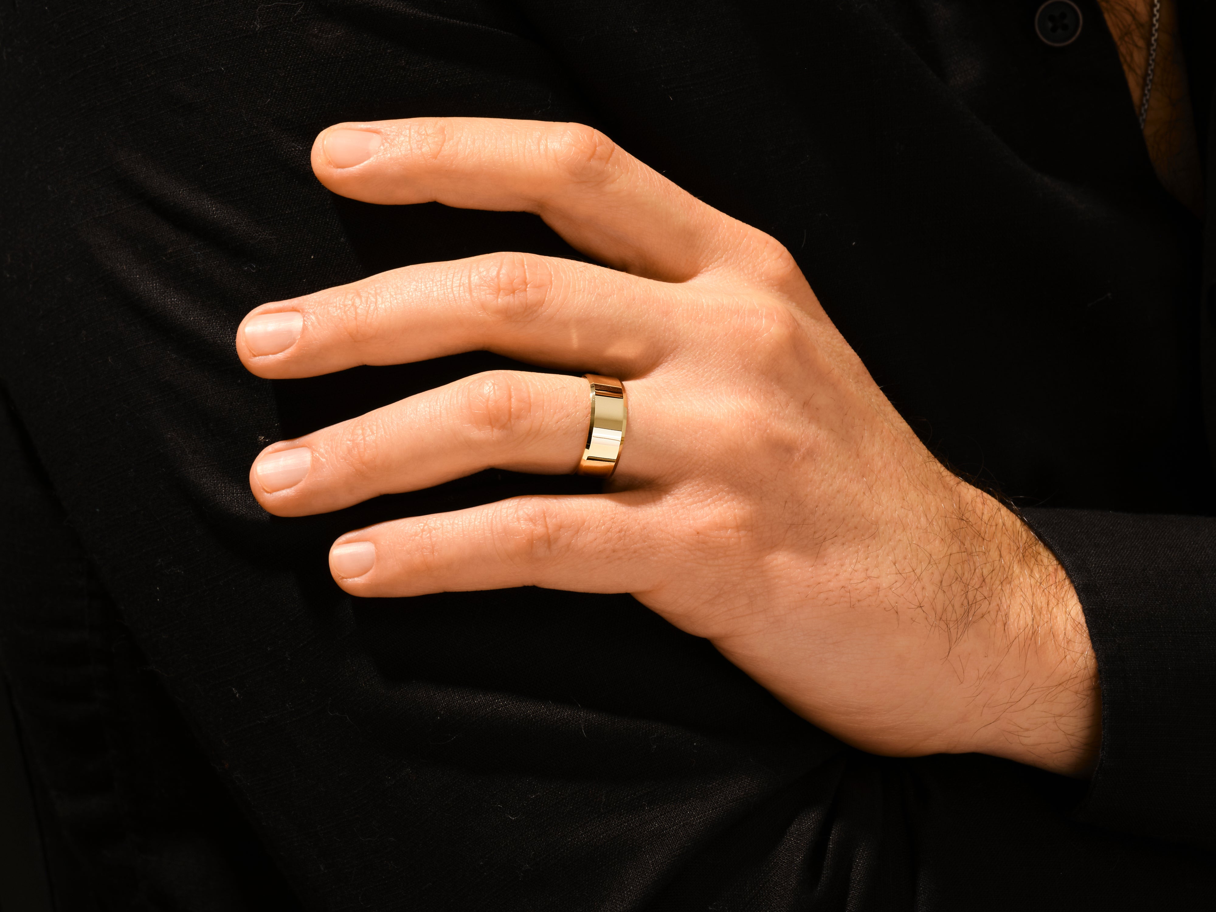 Gold wedding band on a man's hand, jewelry for him