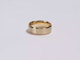 A video showing a yellow gold 8mm matte beveled edge men's wedding band spinning on a white background.
