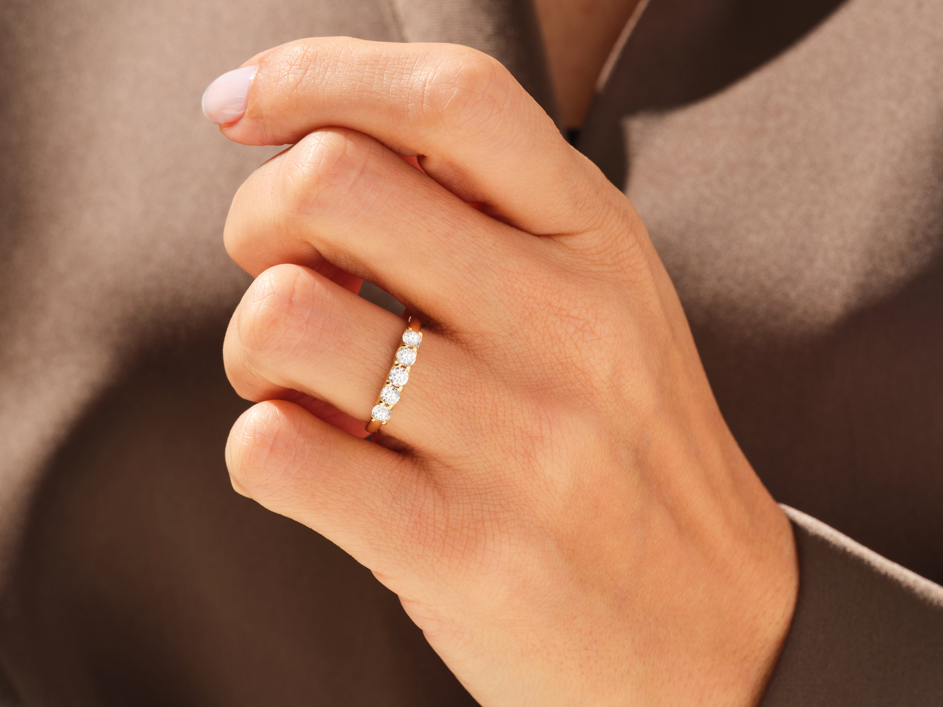 Diamond eternity band on a woman's finger, fine jewelry