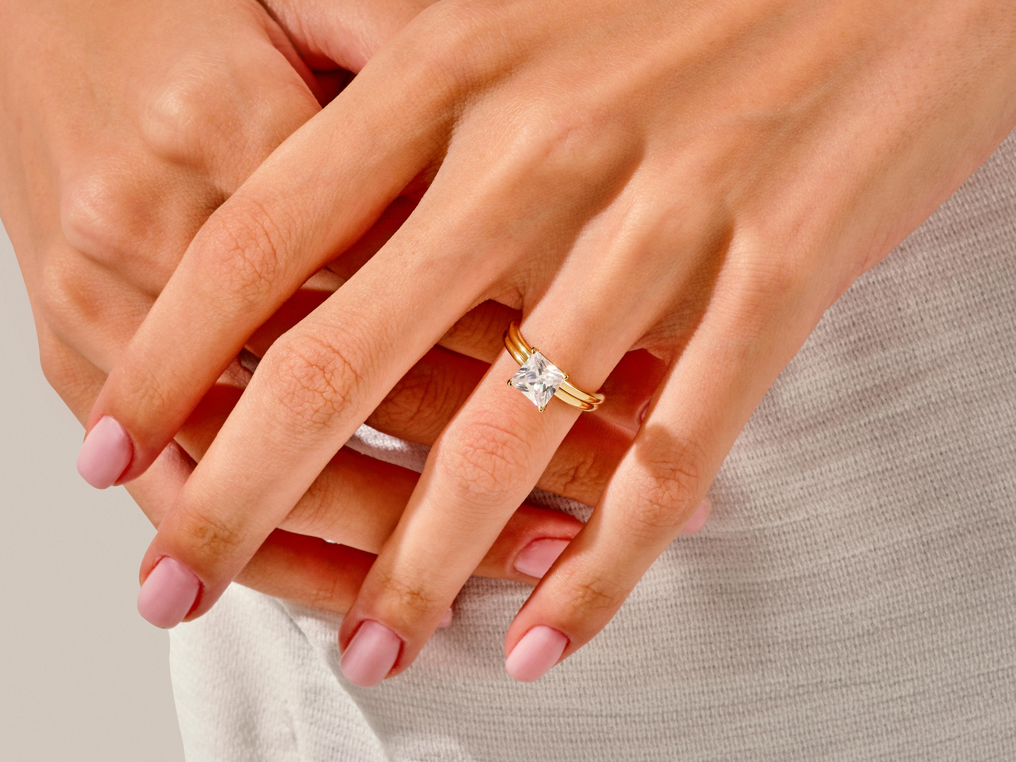 Gold ring with princess cut diamond on a woman's hand