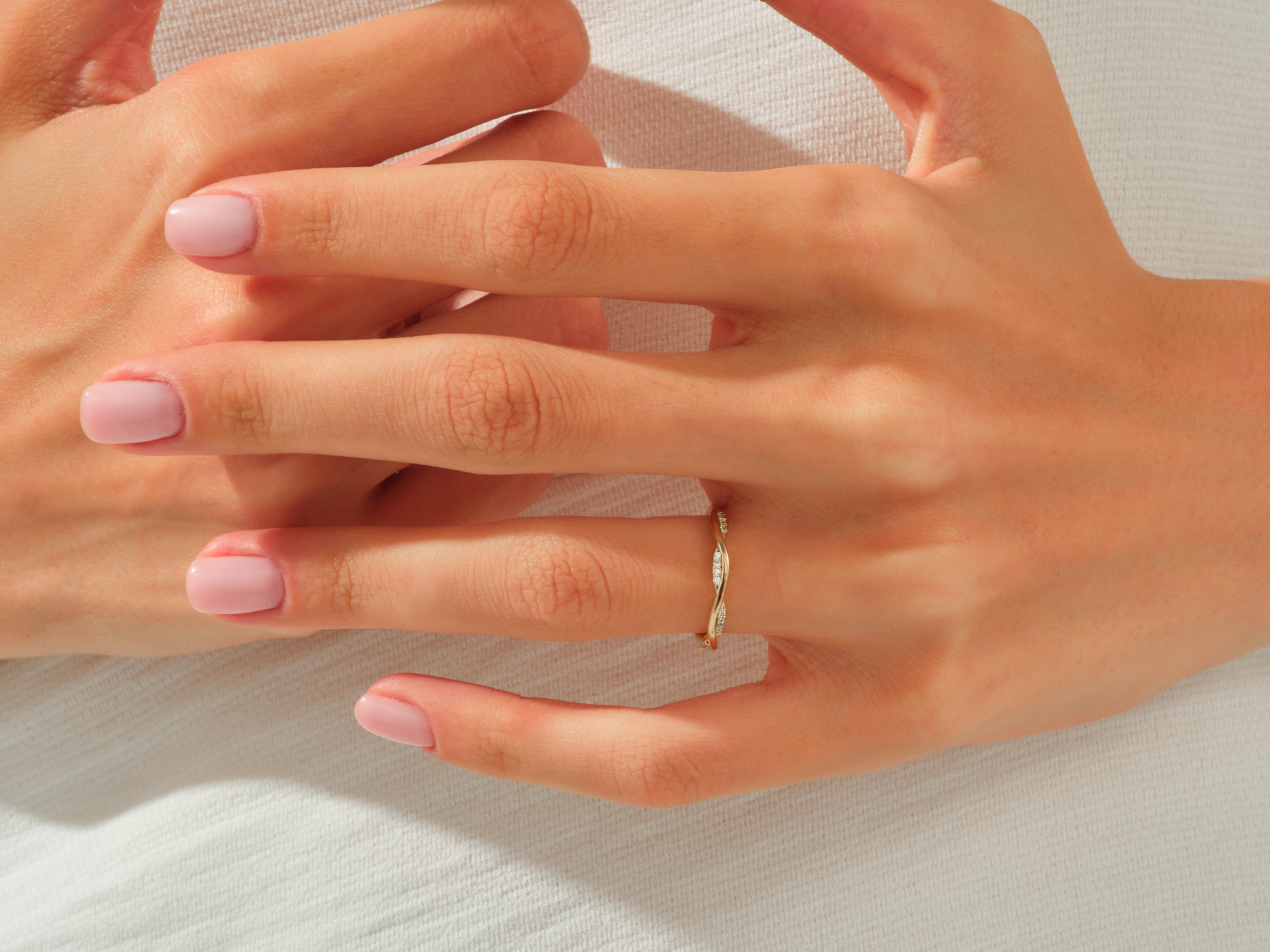 Diamond twisted band ring on a woman's hand