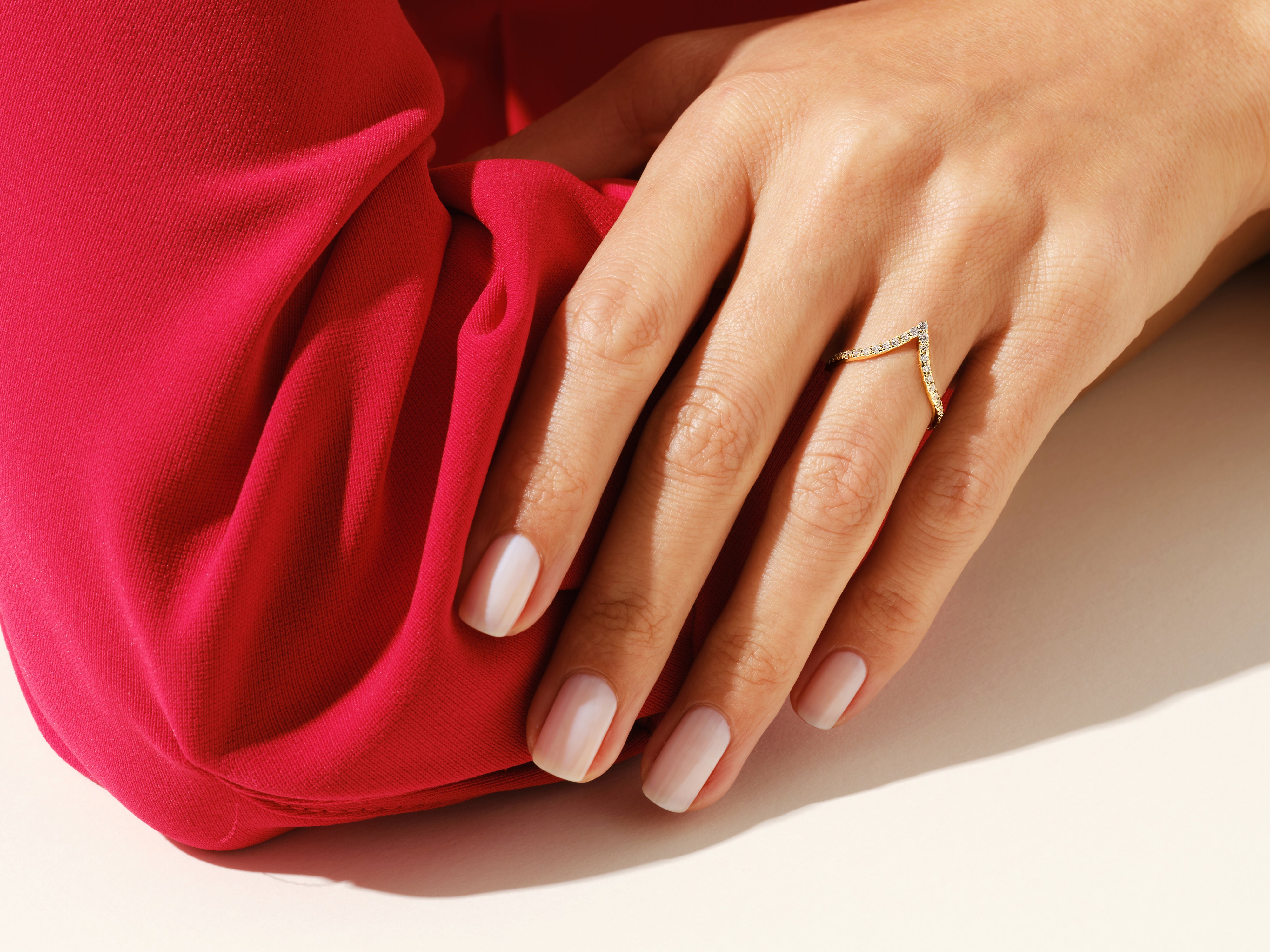 Diamond chevron ring on hand with red fabric jewelry