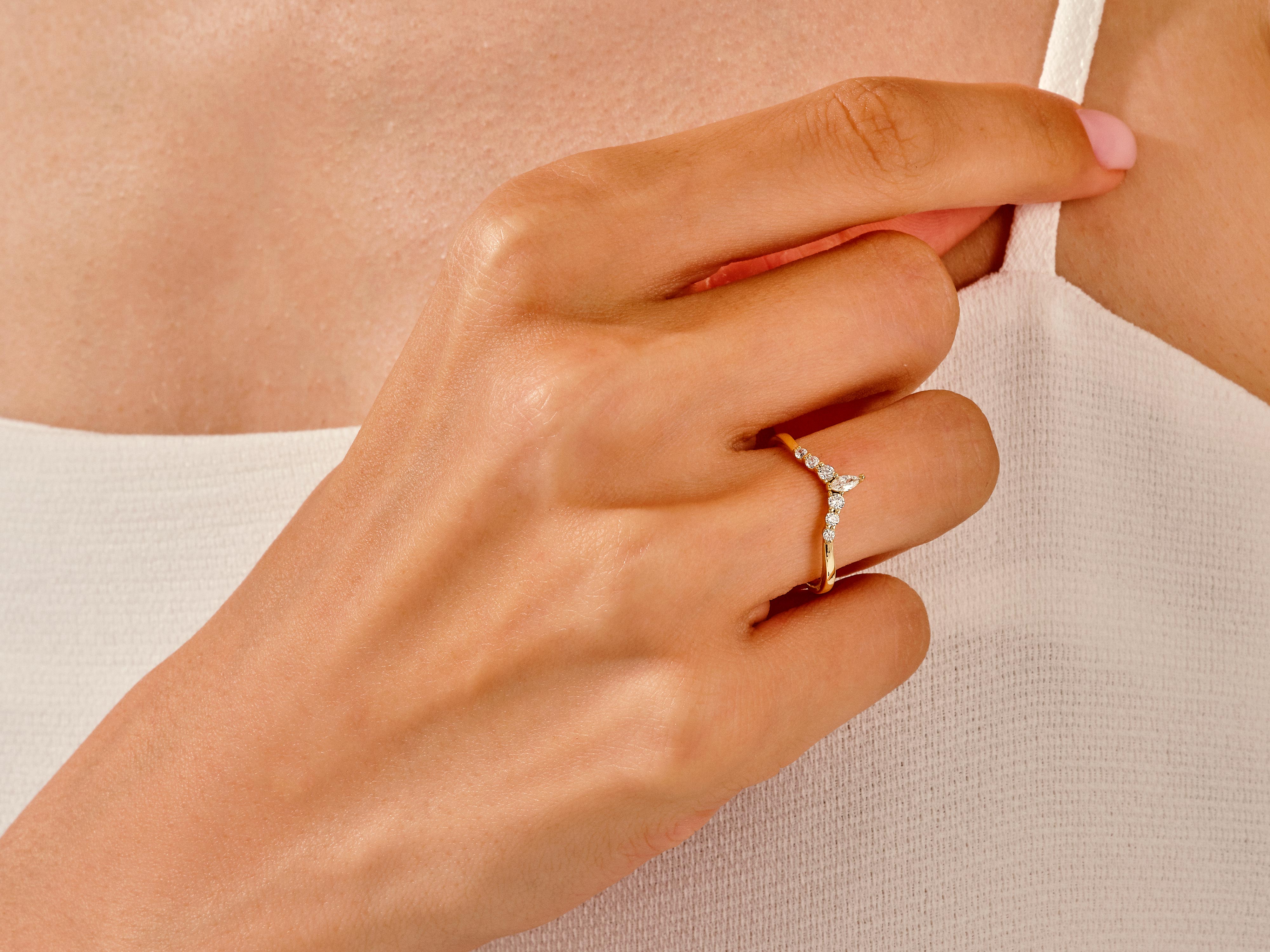 Gold diamond curved ring on a woman's finger