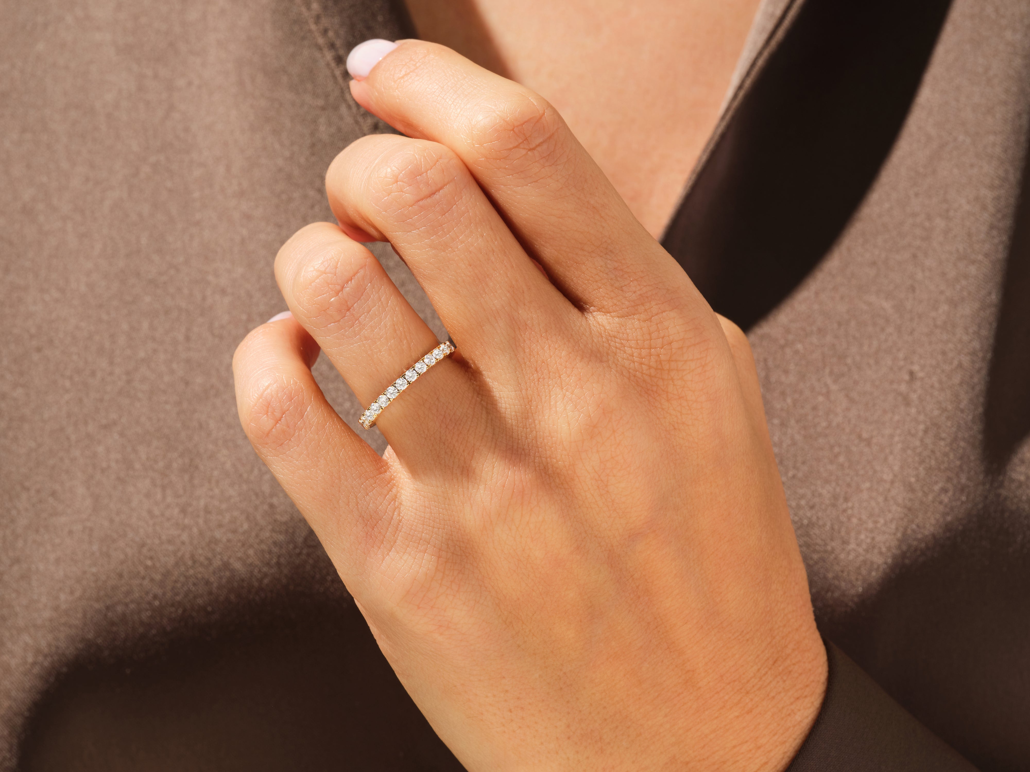 Diamond eternity band on a hand, fine jewelry for women