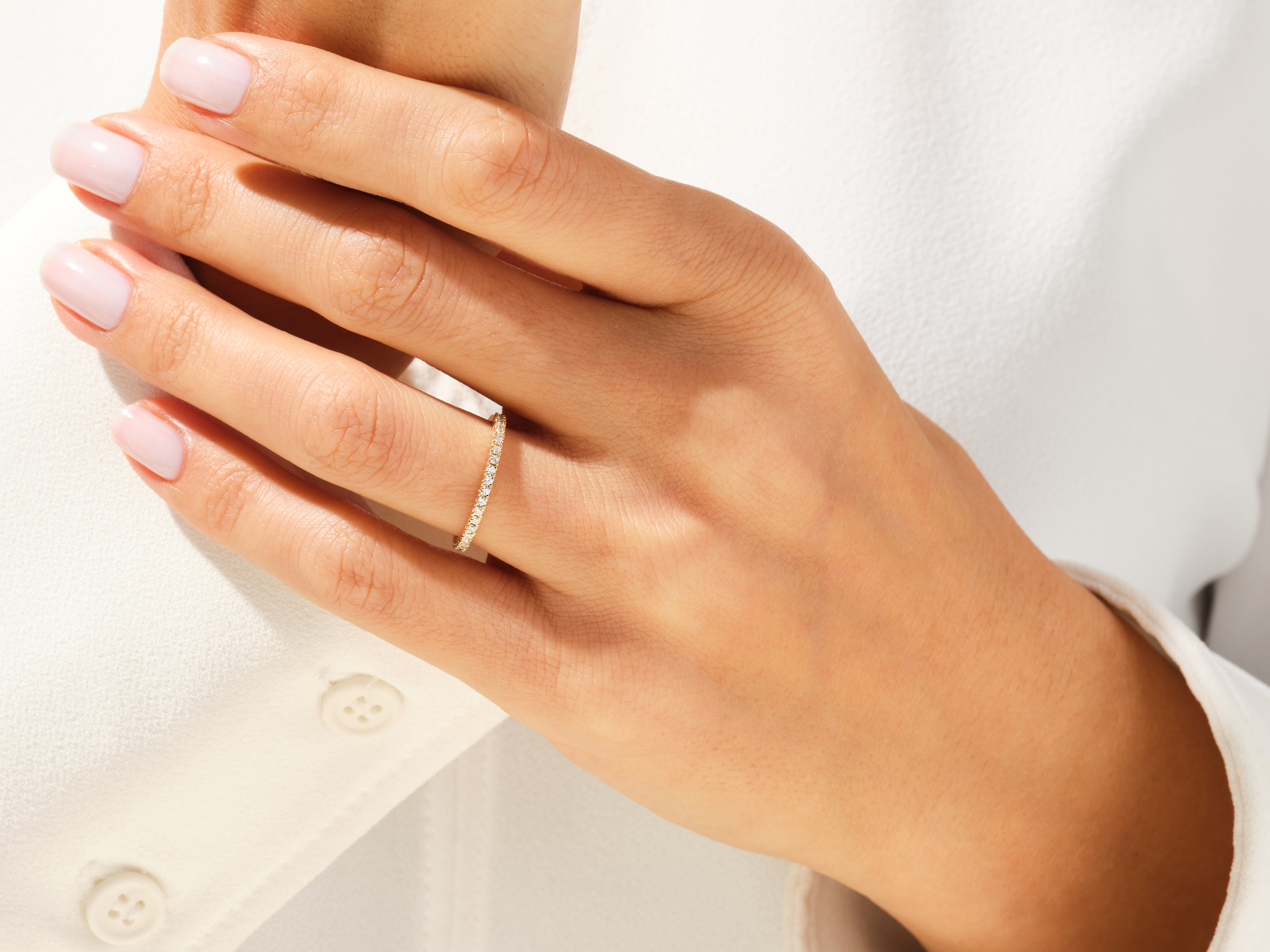 Diamond eternity band on a woman's finger, jewelry