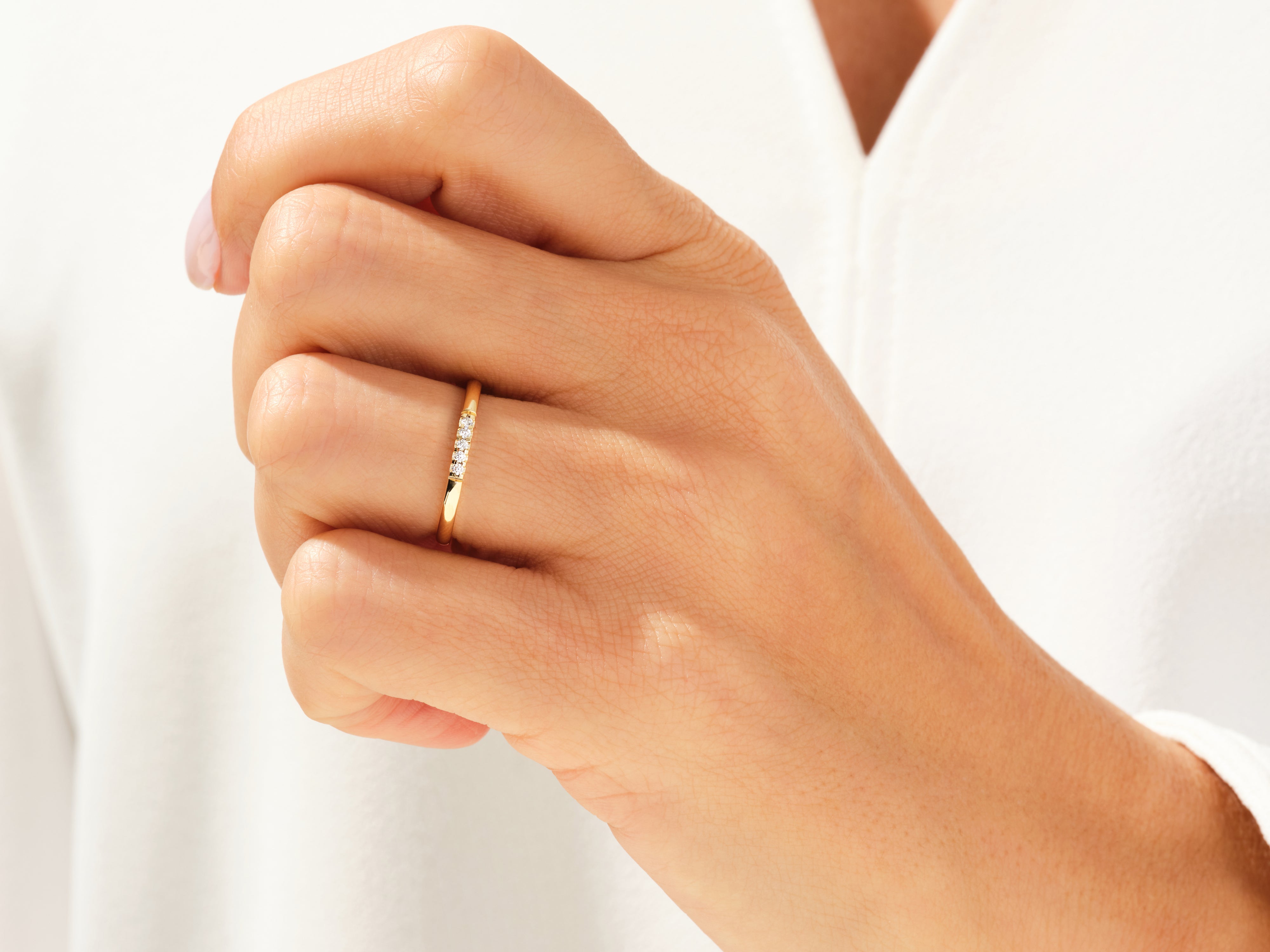 Delicate gold ring with diamonds on a woman's hand