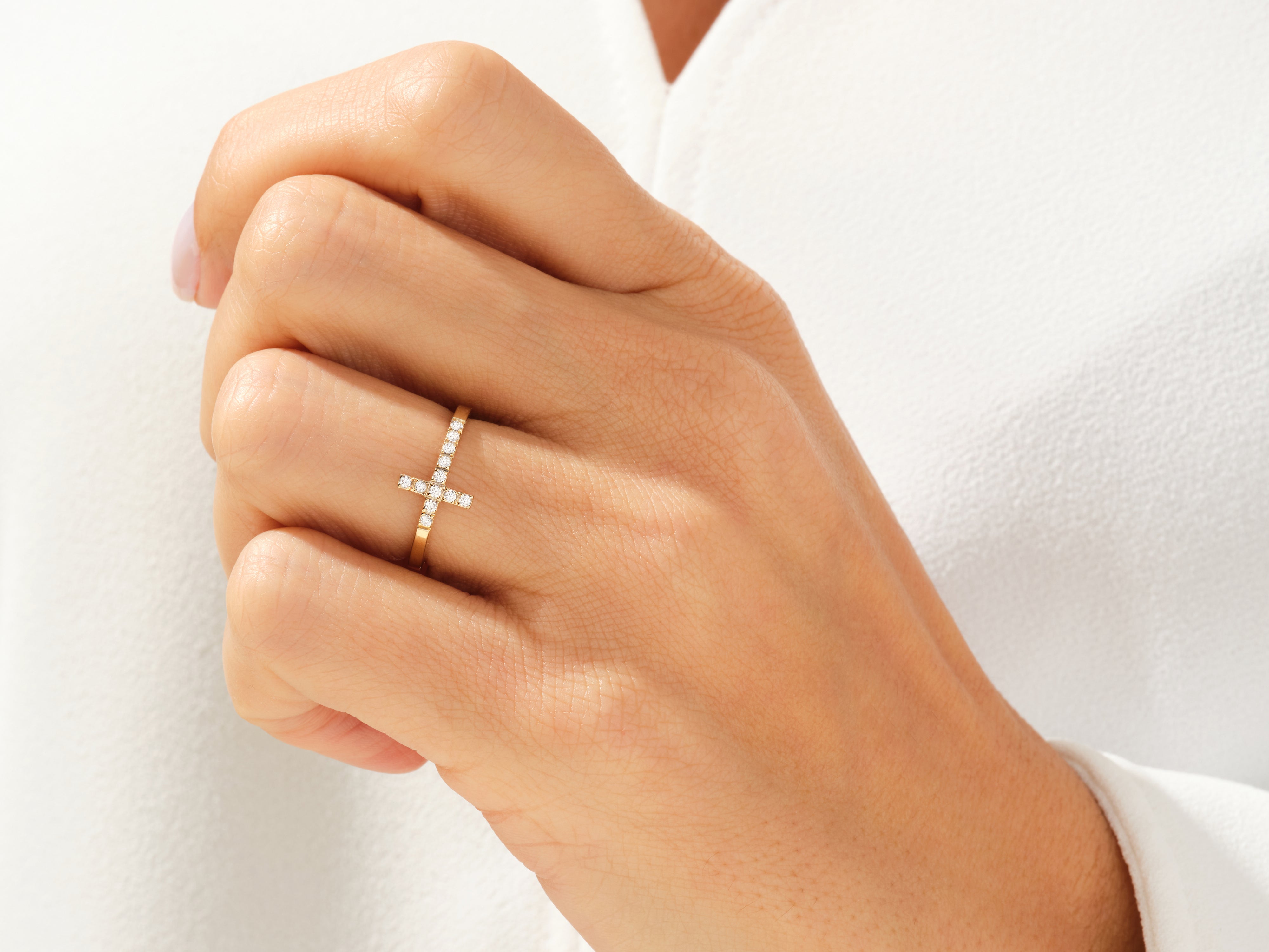 Diamond cross ring on a woman's hand