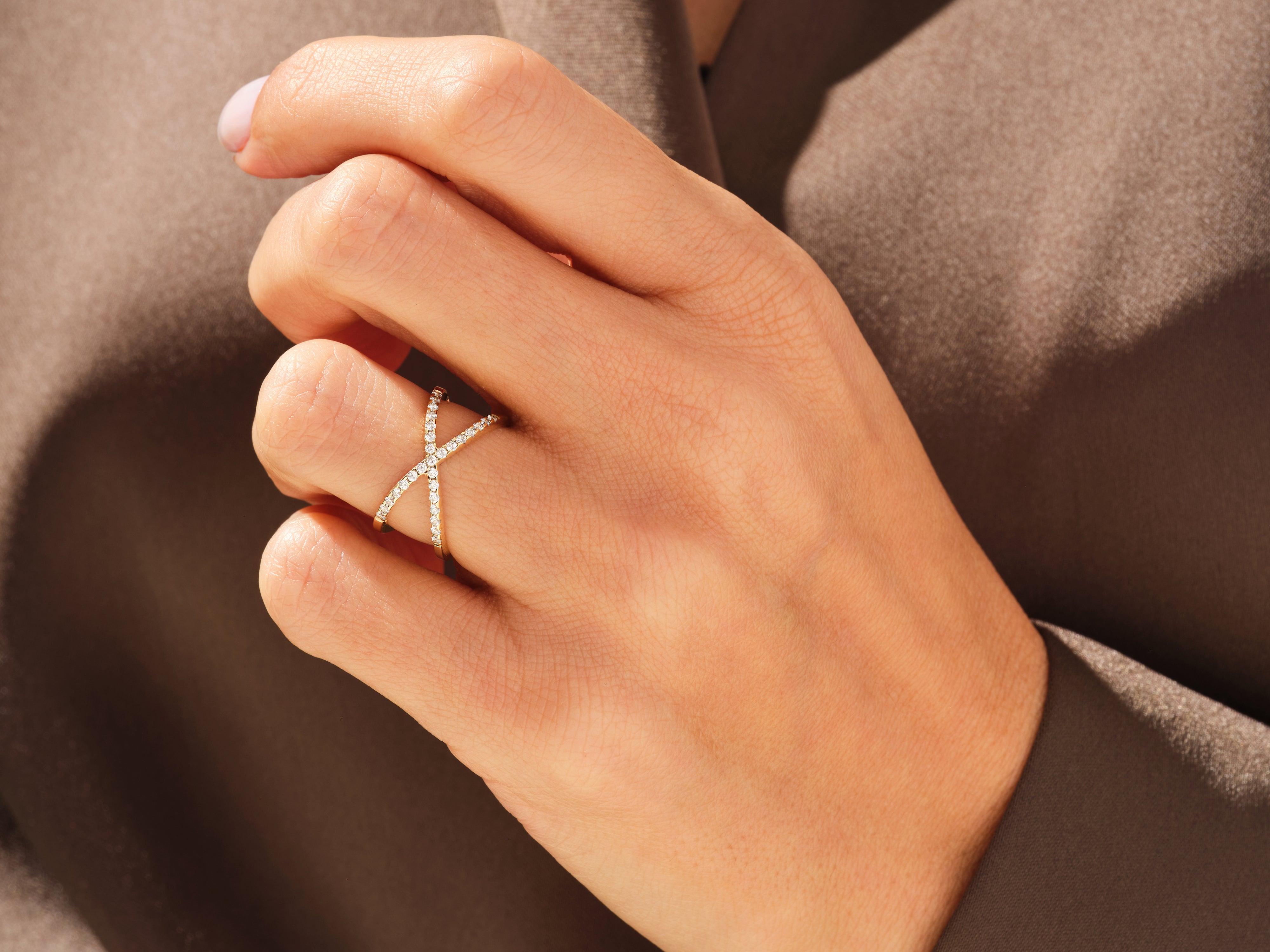 Diamond criss-cross ring on a hand, fine jewelry for women