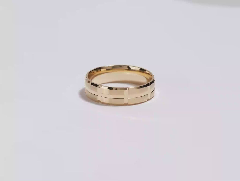 A video showing a yellow gold 6mm grooved block men's Gold wedding band spinning on a white background.