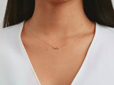 A video of a women model showing a yellow gold bezel setting round three stones birthstone family necklace on her neck